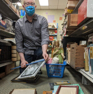 An employee with a shopping basket is measuring frames