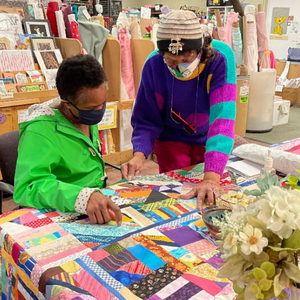 Artist and guest look at a quilt