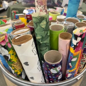 Rolls of wrapping paper sticking out of a barrel.